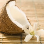 Half Coconut and Flower on Bamboo Mat --- Image by © Royalty-Free/Corbis